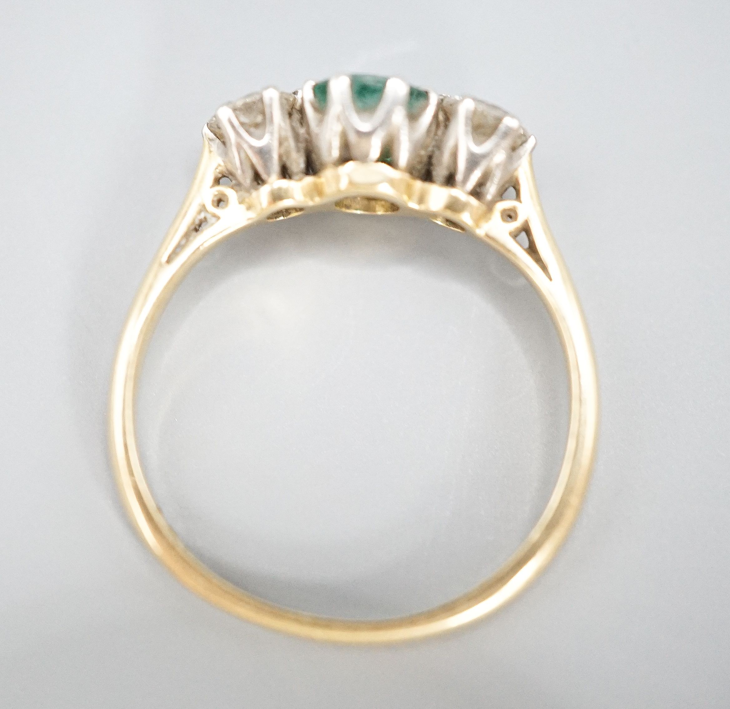 An 18ct and plat, emerald and diamond set three stone ring, size K, gross weight 2.3 grams.